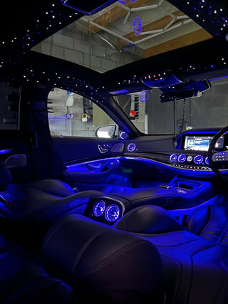 Luxurious car interior with starlight ceiling and blue LED footwell lighting, showcasing a sleek design and DIY upgrade potential.